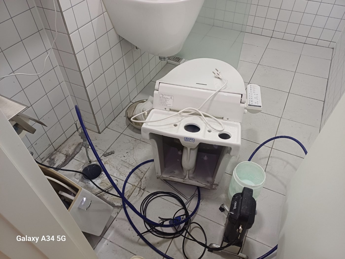 욕실 변기를 옮기고 배수 접합부를 확인하는 전체 모습